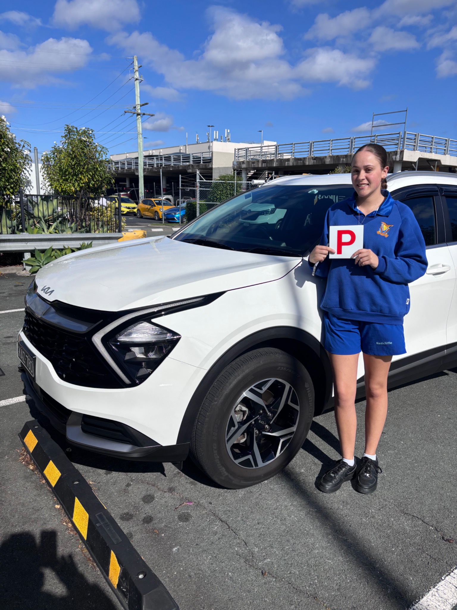 Lilly proudly holding her P plate after passing her driving test on the first attempt