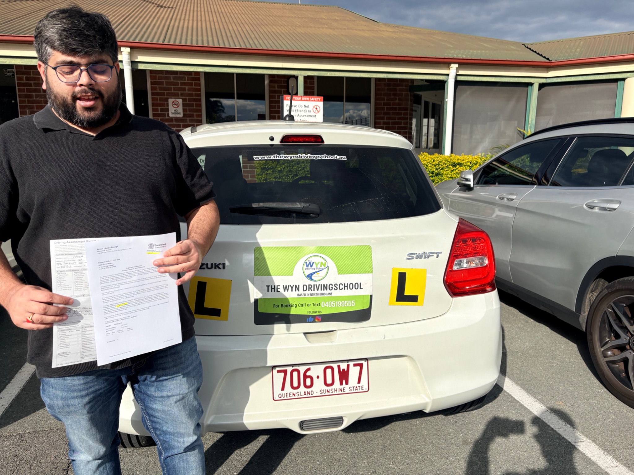 Sidharth celebrating after passing his driving test on the first attempt while holding an overseas licence